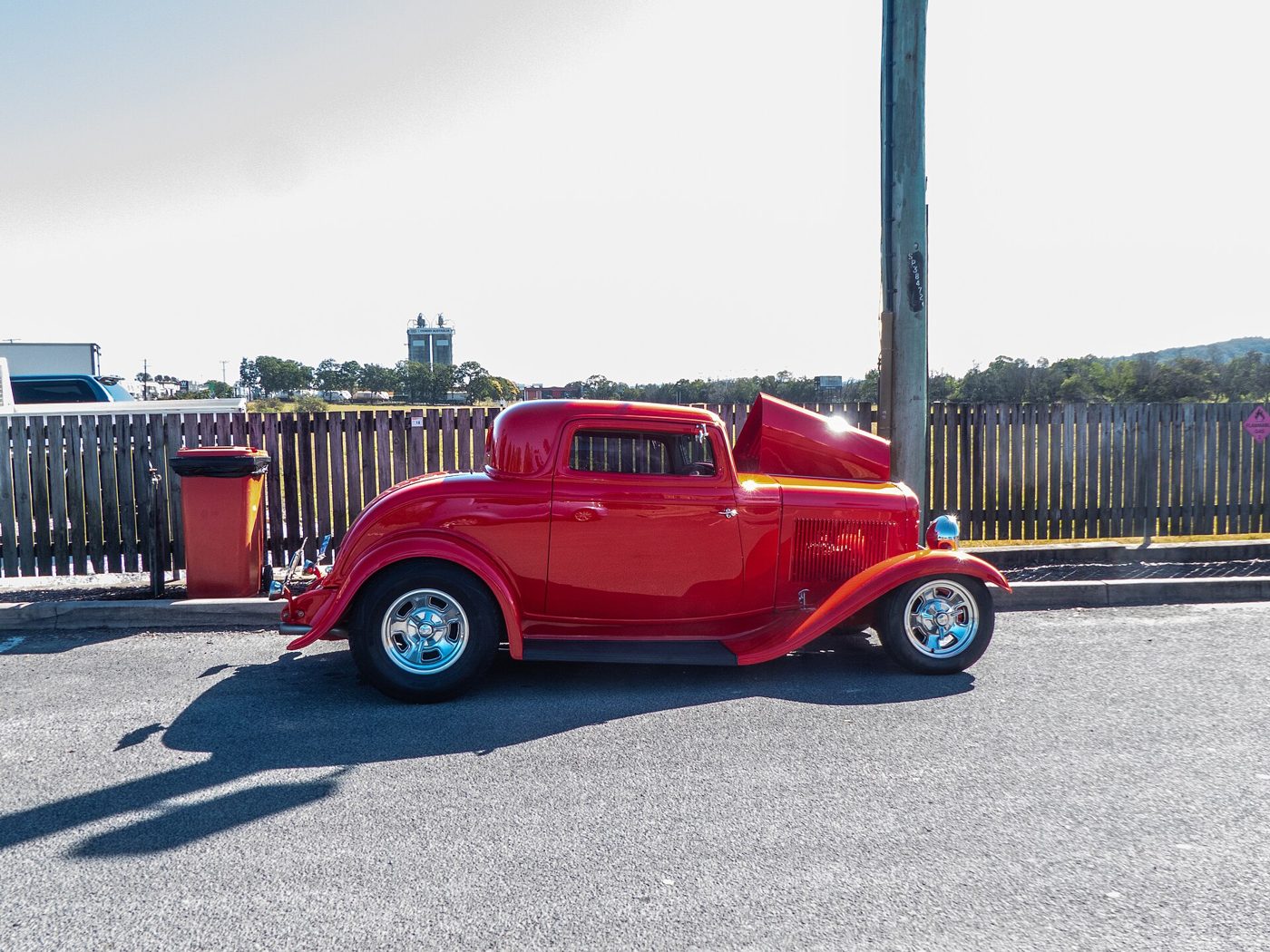 Röd Ford hot rod-coupé från 1932 i sidoprofil i solsken